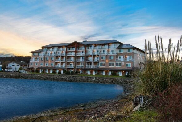 Oxford Suites Silverdale overlooking Dyes Inlet at sunset, with waterfront views of Puget Sound and landscaped shoreline.