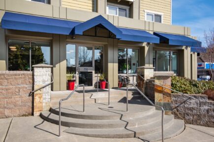 Exterior entrance of Marshall Suites Bainbridge Island, SureStay Collection by Best Western, with covered entry and landscaped approach on Bainbridge Island, Washington.