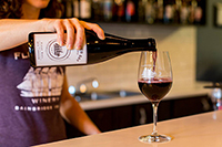 photo of bartender pouring glass of wine at Fletcher Bay Winery