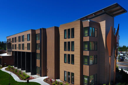 Exterior of The Point Casino and Hotel in Kingston, Washington, showing modern architecture surrounded by landscaped grounds and clear blue sky.
